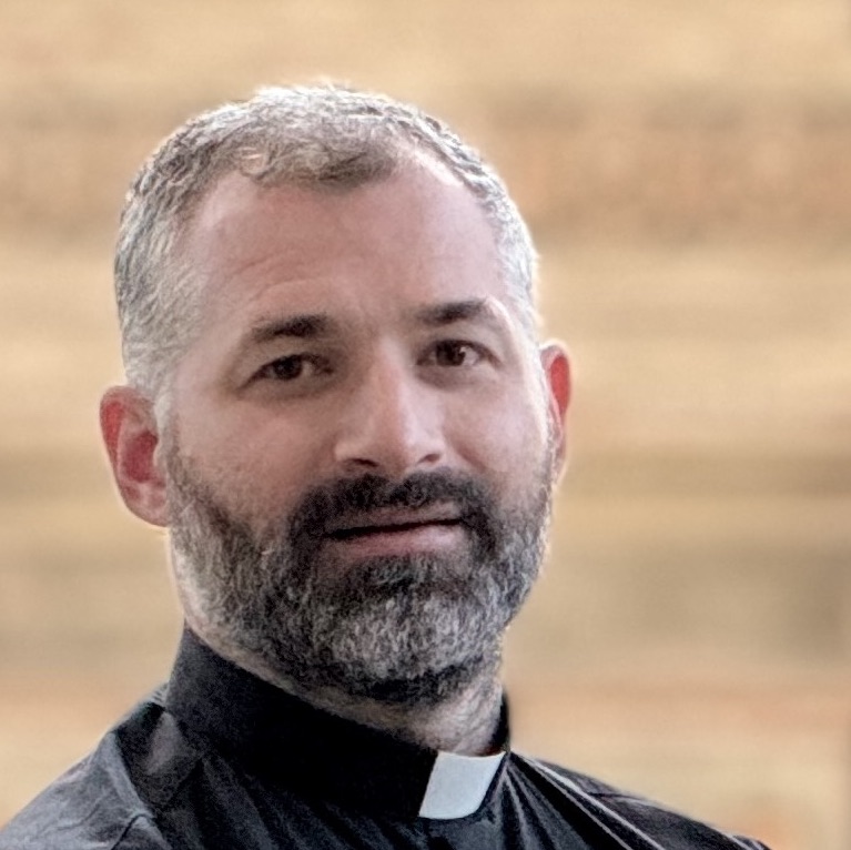 Porträt eines Mannes mit Bart und Priesterkragen.