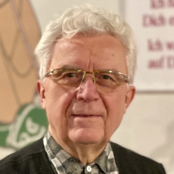 Porträt eines älteren Mannes mit weißen Haaren und Brille.