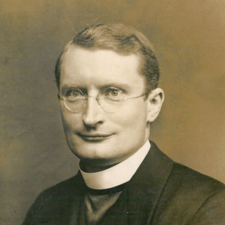 Sepia-Porträt eines Mannes mit Brille und Priesterkragen.